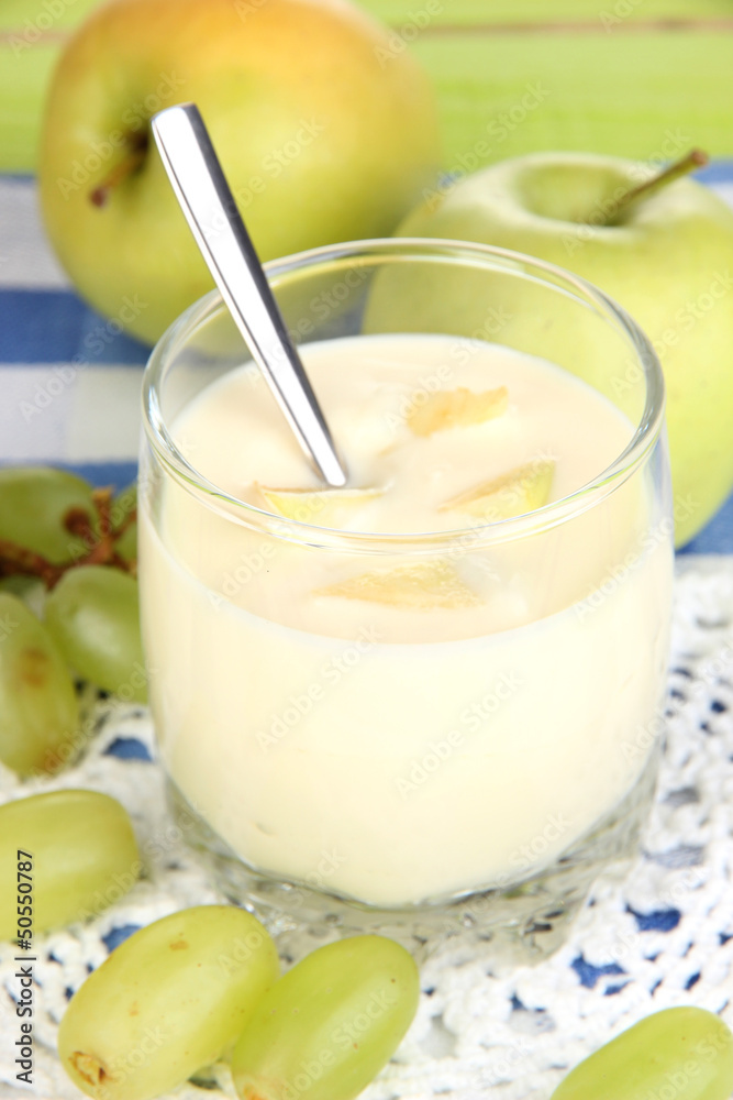 Delicious yogurt in glass with fruit on blue tablecloth Delicious yogurt in glass with fruit on blue tablecloth