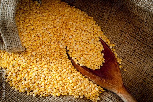 Raw moong dhal in jute bag and wooden scoup photo