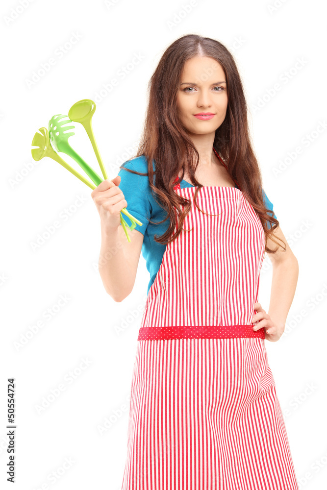 Young woman wearing red apron and holding plastic spoons Young woman wearing red apron and holding plastic spoons