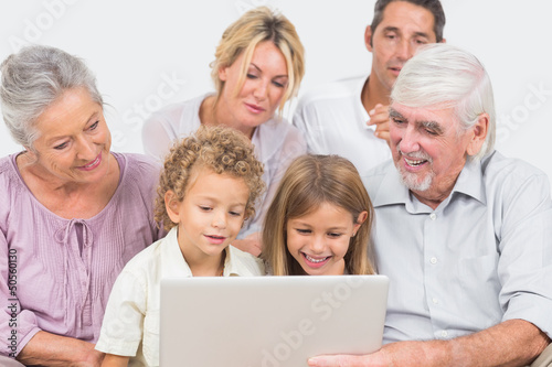 Joyful family watching a laptop screen together © WavebreakmediaMicro