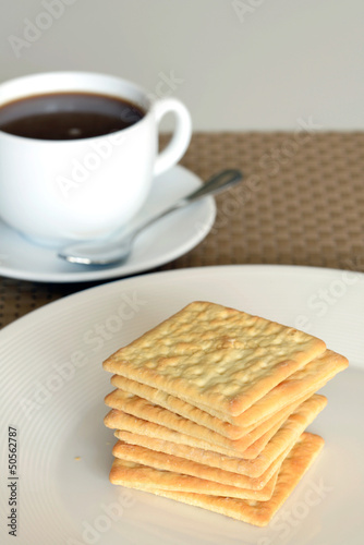 Close-up of cream cracker cookie and hot coffee