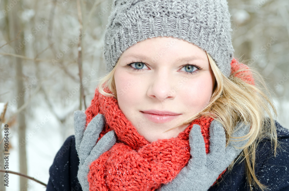 junge blonde Frau mit Mütze und Schal Winterwald Portrait