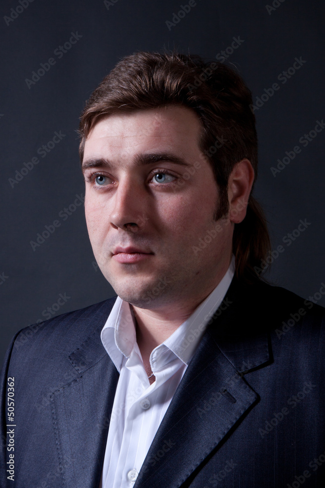 man in a black suit with a gray background man in a black suit with a gray background