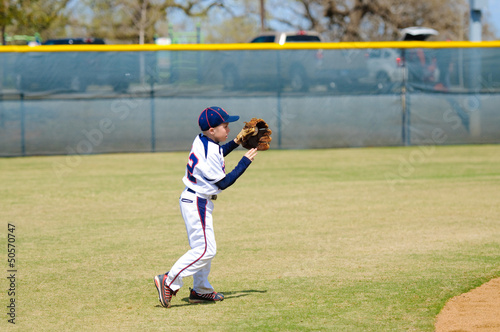 Youth shortstop about to throw ball