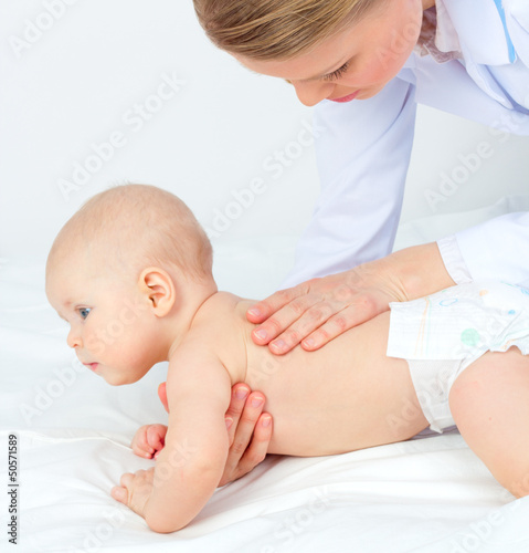 Baby massage. Doctor massaging child back