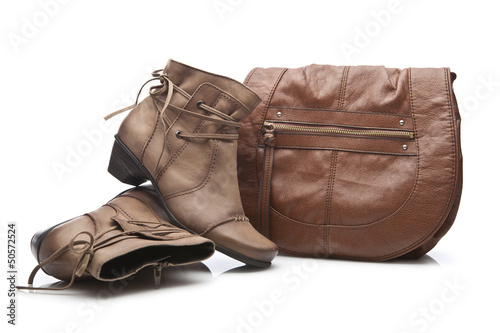 Pair of female shoes and handbag over white