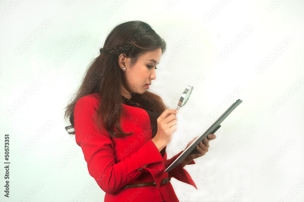 Asian woman looking a clipboard with magnifying glass. Asian woman looking a clipboard with magnifying glass.