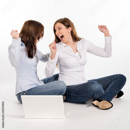 two women sitting on the flor and cheering