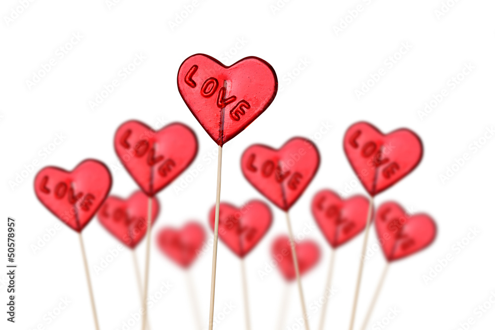 Red heart shaped lollipops on white background.
