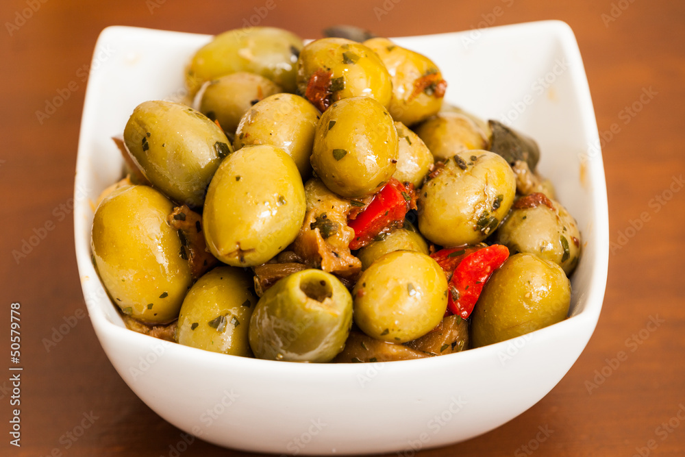 Varitey of olives into into bowls on wooden table Varitey of olives into into bowls on wooden table