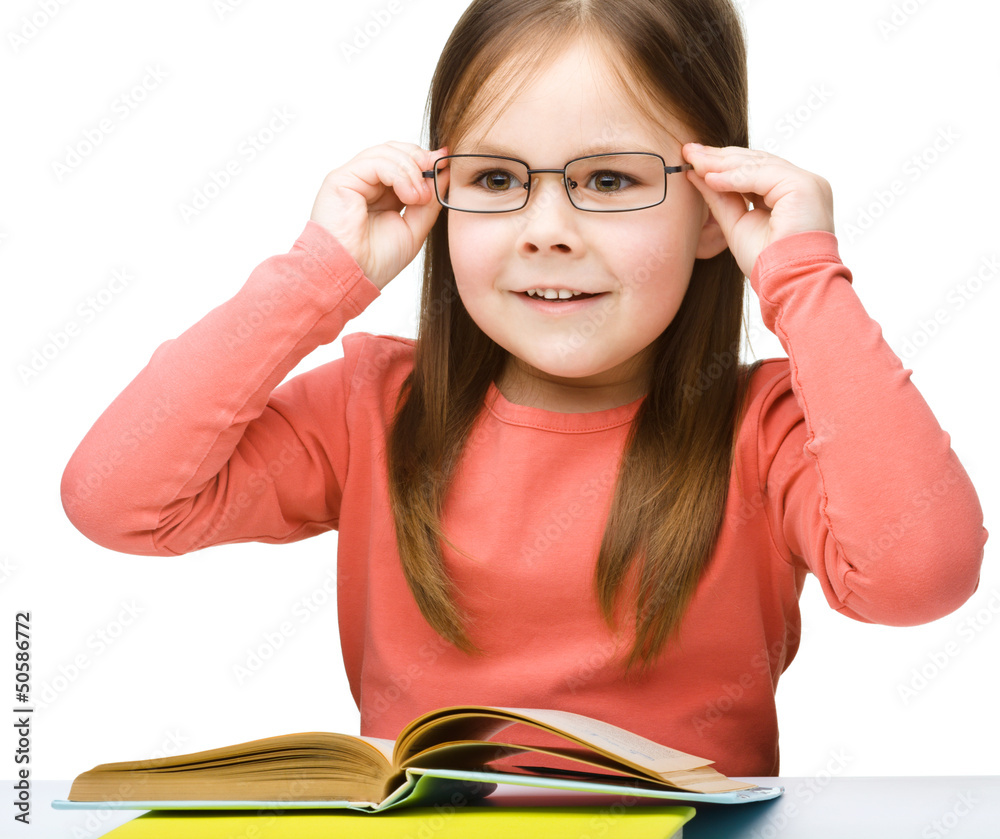 Little girl is reading a book
