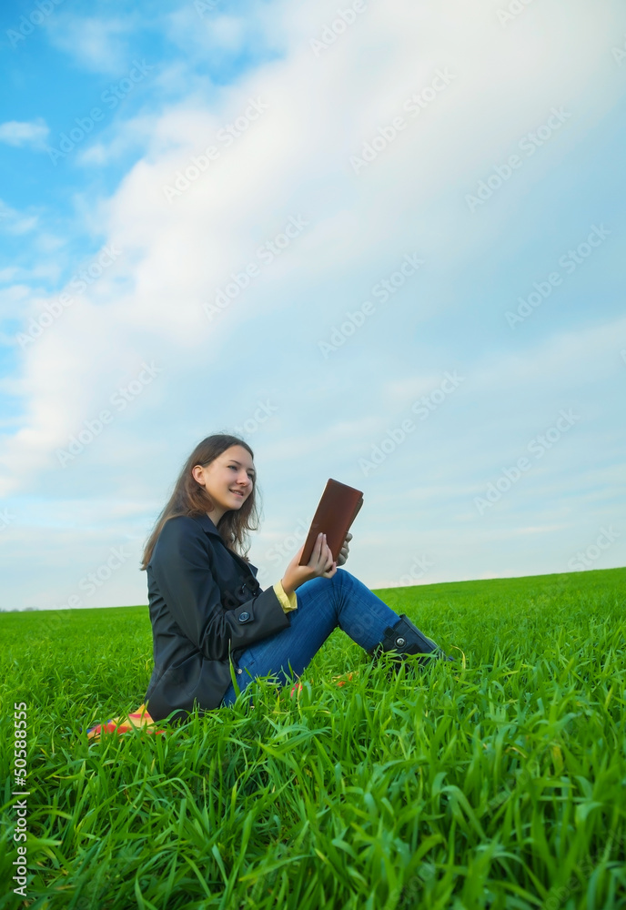 Teen girl reading the Bible outdoors