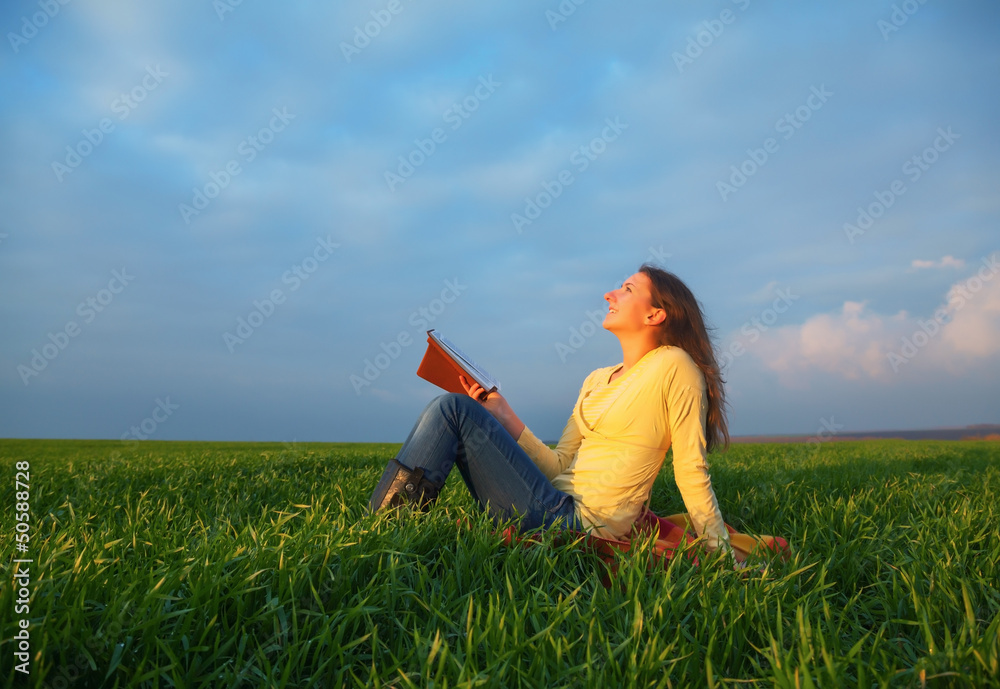 Teen girl reading the Bible outdoors