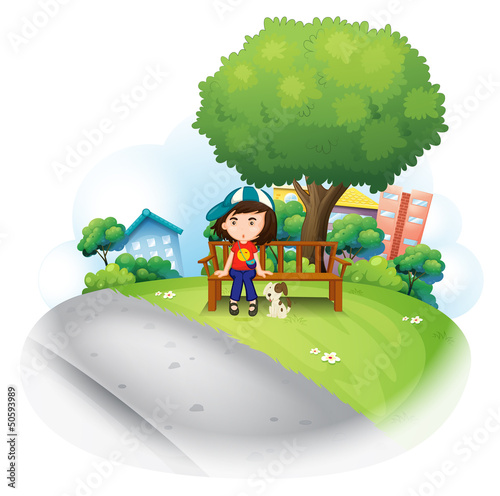 A girl sitting at the wooden bench near the big tree