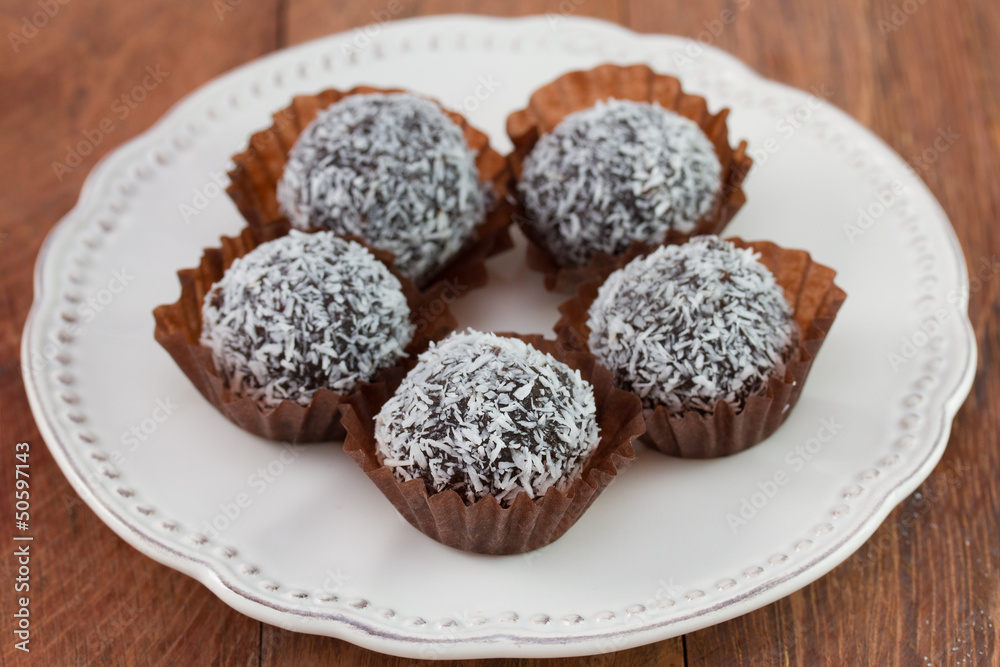 chocolate truffles with coconut on the white plate chocolate truffles with coconut on the white plate
