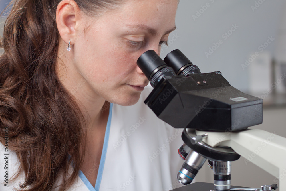 Young female doctor with microscope