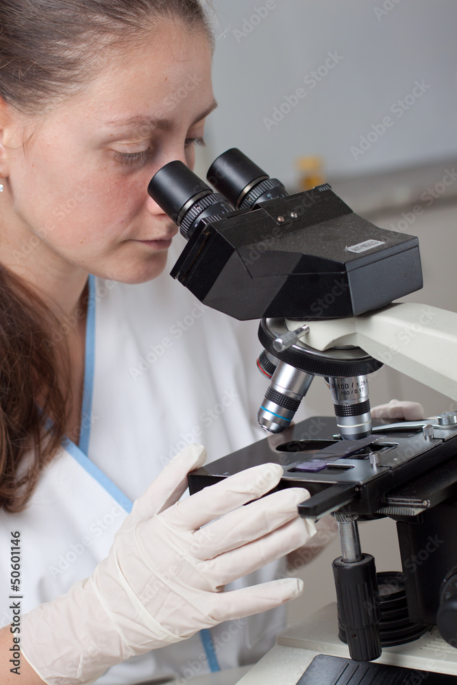 Young female doctor with microscope