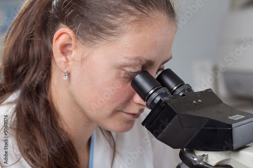 Fototapeta Naklejka Na Ścianę i Meble -  Young female doctor with microscope
