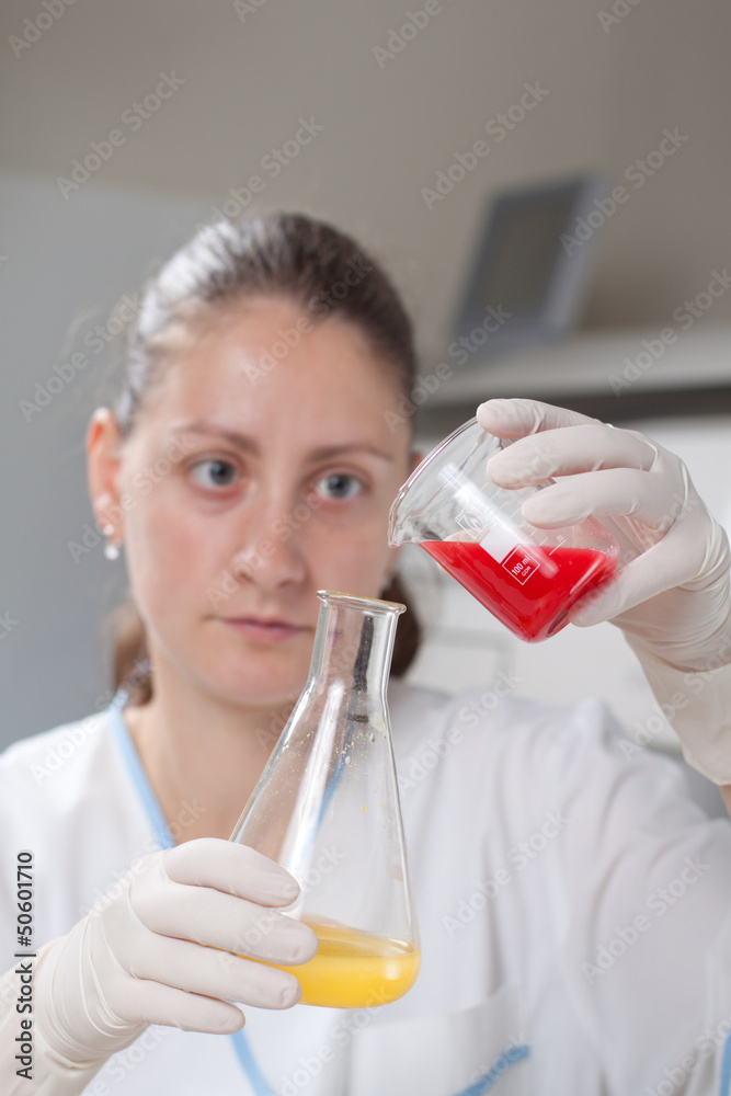Woman examine colorful bottles fill with chemicals Woman examine colorful bottles fill with chemicals