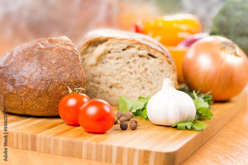 Garlic, tomato and parsley on a chopping board Garlic, tomato and parsley on a chopping board