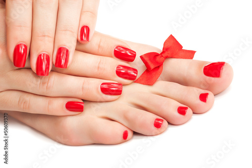 Red manicure and pedicure with a bow