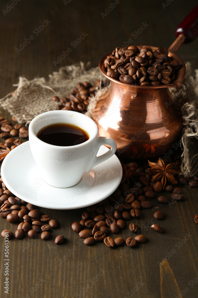 Fototapeta premium Cup of coffee and pot on wooden background
