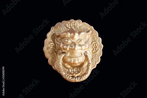 Golden lion head knocker isolated on the black background