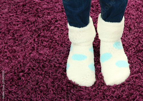 Female legs in colorful socks on color carpet background
