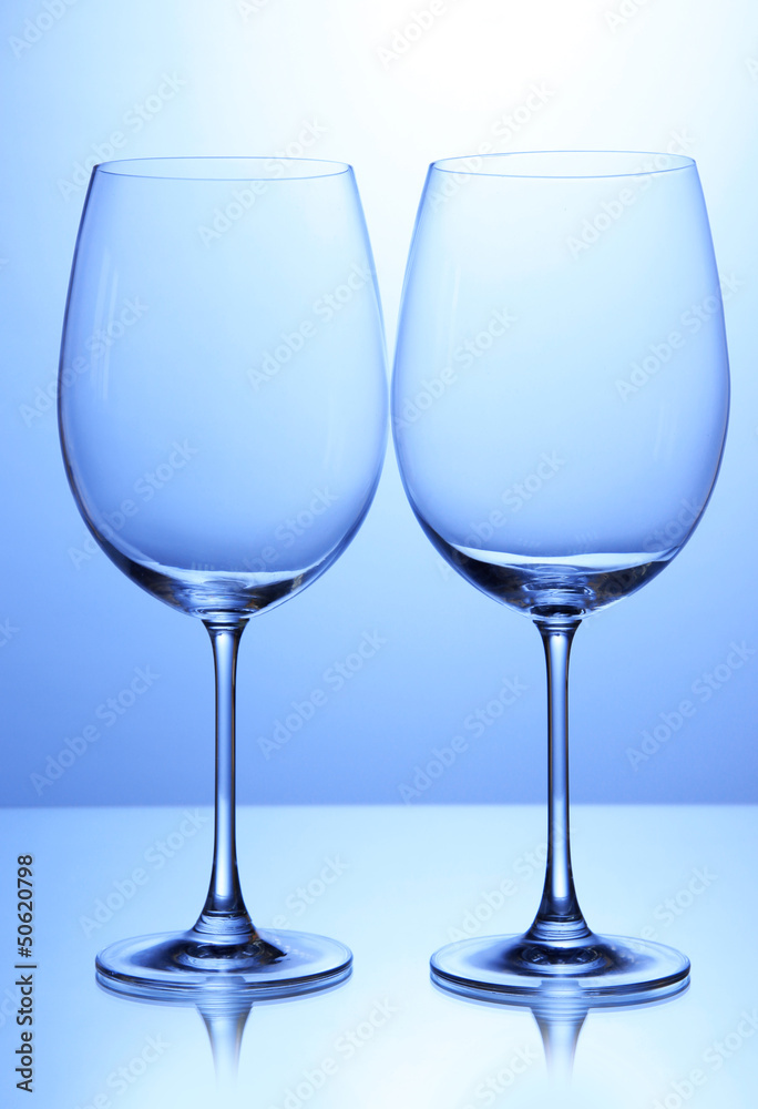 Empty wine glasses arranged on blue background Empty wine glasses arranged on blue background