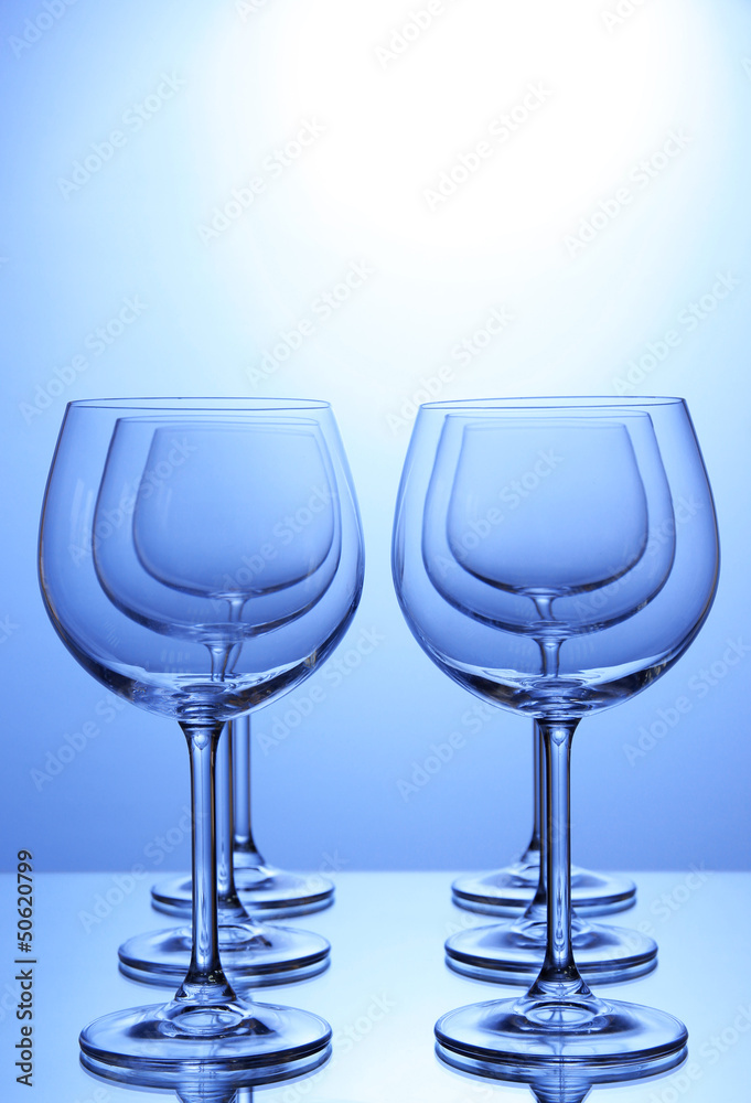 Empty wine glasses arranged on blue background