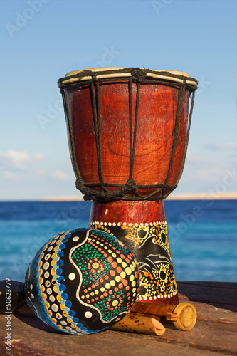Canvas Print maracas and ethnic drum on the beach