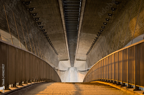 Empty footpath under the massive concrete highway bridge