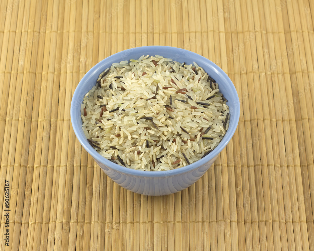 China rise in blue bowl on brown straw mat closeup China rise in blue bowl on brown straw mat closeup