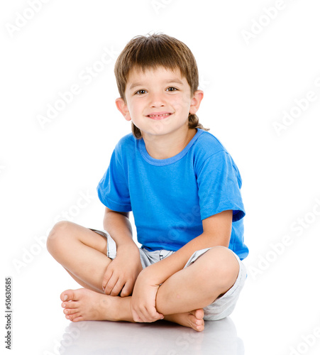 Portrait of young boy sitting isolated over a white background