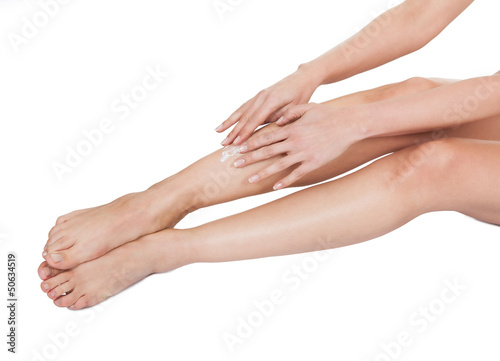 Woman Applying Cream To Her Legs