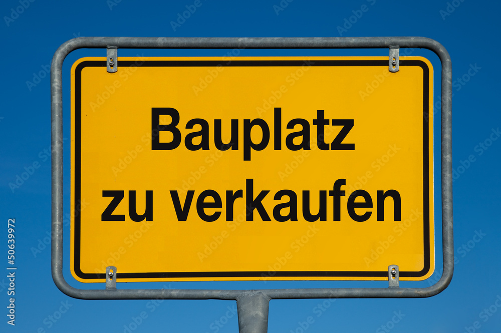 Ortsschild mit blauem Himmel BAUPLATZ ZU VERKAUFEN Ortsschild mit blauem Himmel BAUPLATZ ZU VERKAUFEN