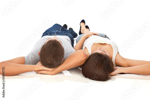 Young couple together lying with arms behind head