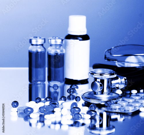 Medicines and stethoscope in blue light