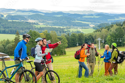 Obraz na płótnie Hikers helping cyclists following track nature landscape w salonie