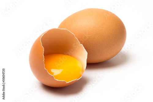 Two eggs, one broken, with shadow isolated on white background photo