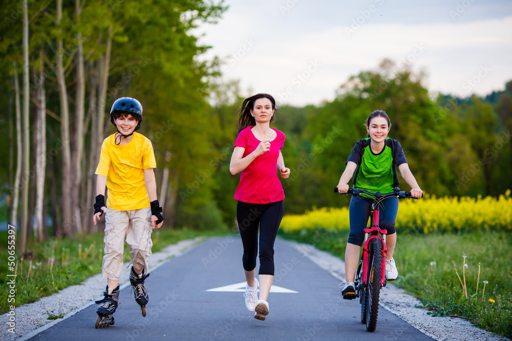 Obraz premium Active family - mother and kids running, biking, rollerblading