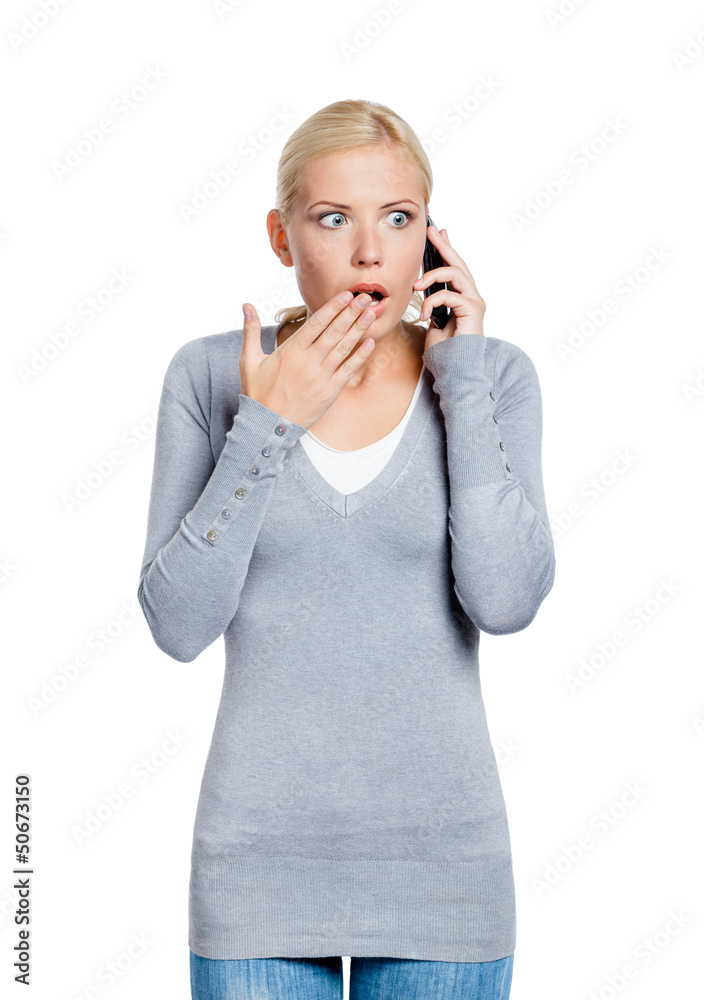 Speaking on phone shocked woman covers her mouth with hand Speaking on phone shocked woman covers her mouth with hand