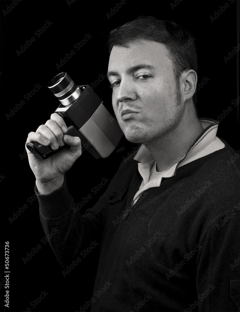 Naklejka premium man posing with cine film / video camera as a gun
