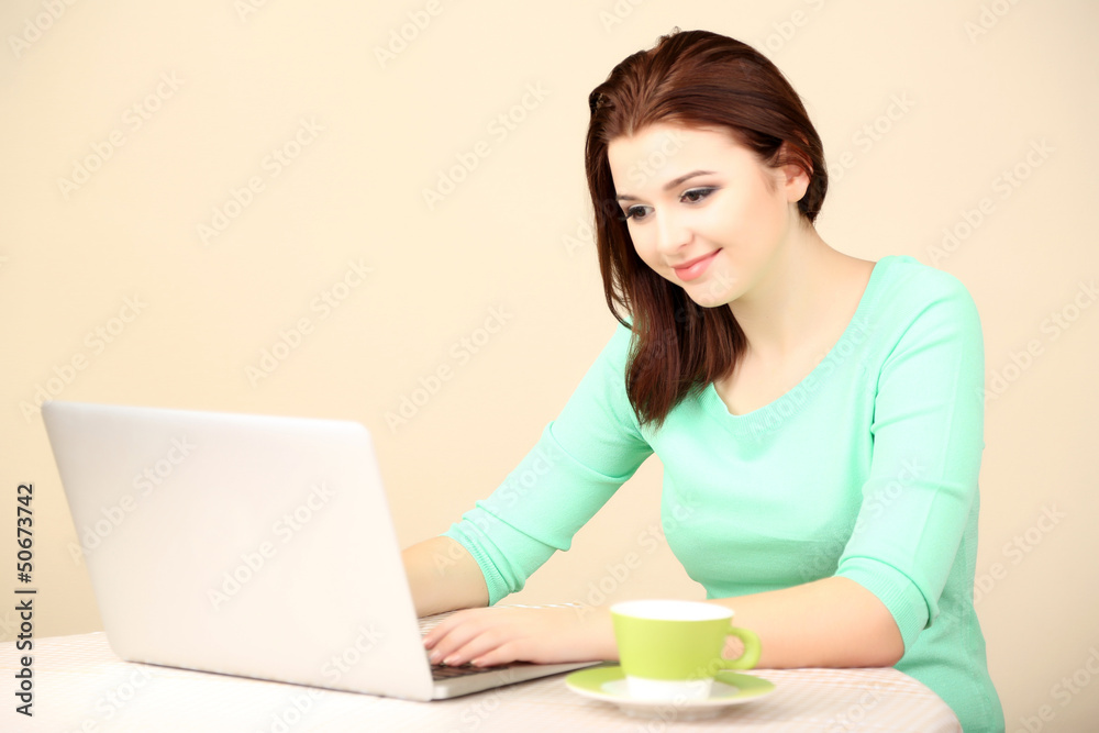 Beautiful young woman working on laptop on light background Beautiful young woman working on laptop on light background