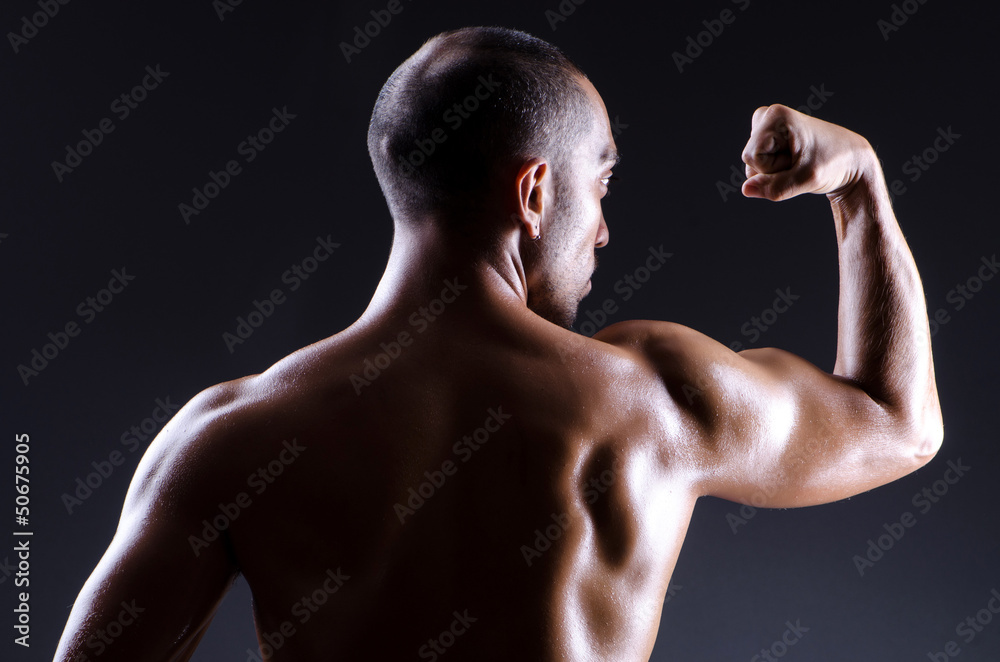 Muscular man in dark studio