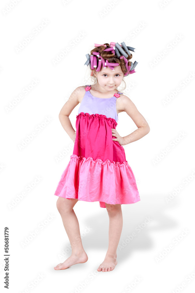Little girl with  hair-curlers in her hair poses with her hands