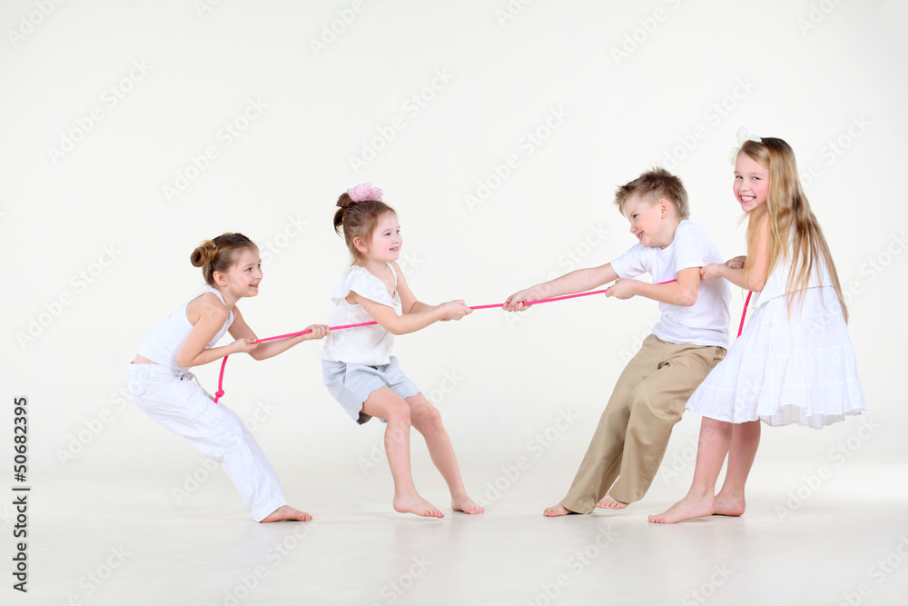 Naklejka premium Four happy little boy and girls in white clothes draw over rope