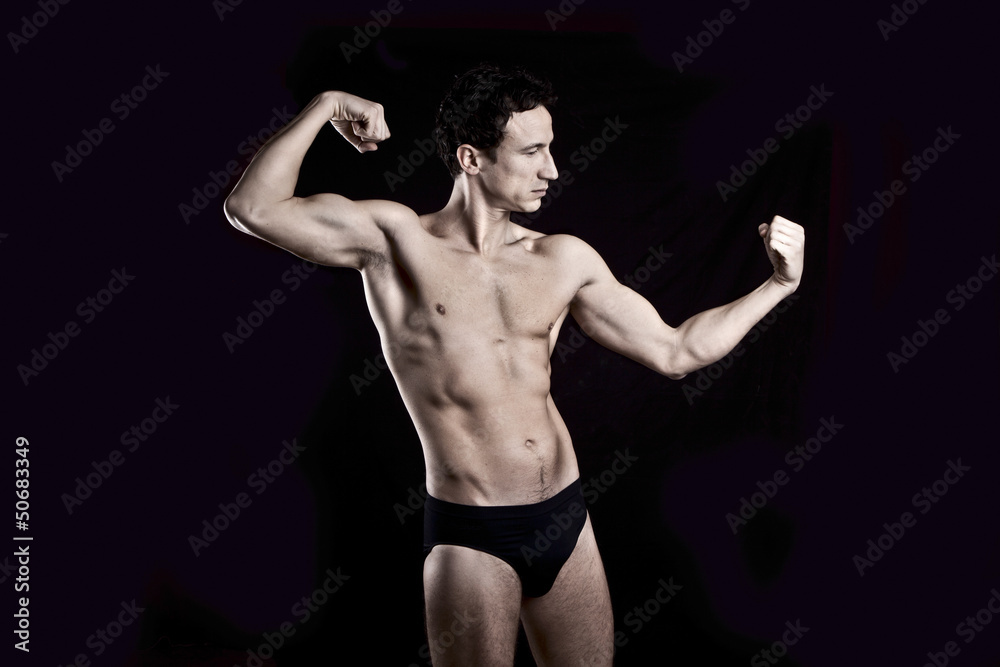 Obraz premium Handsome muscular guy on black background