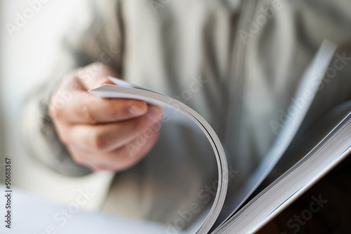 Businessman thumbs through the book