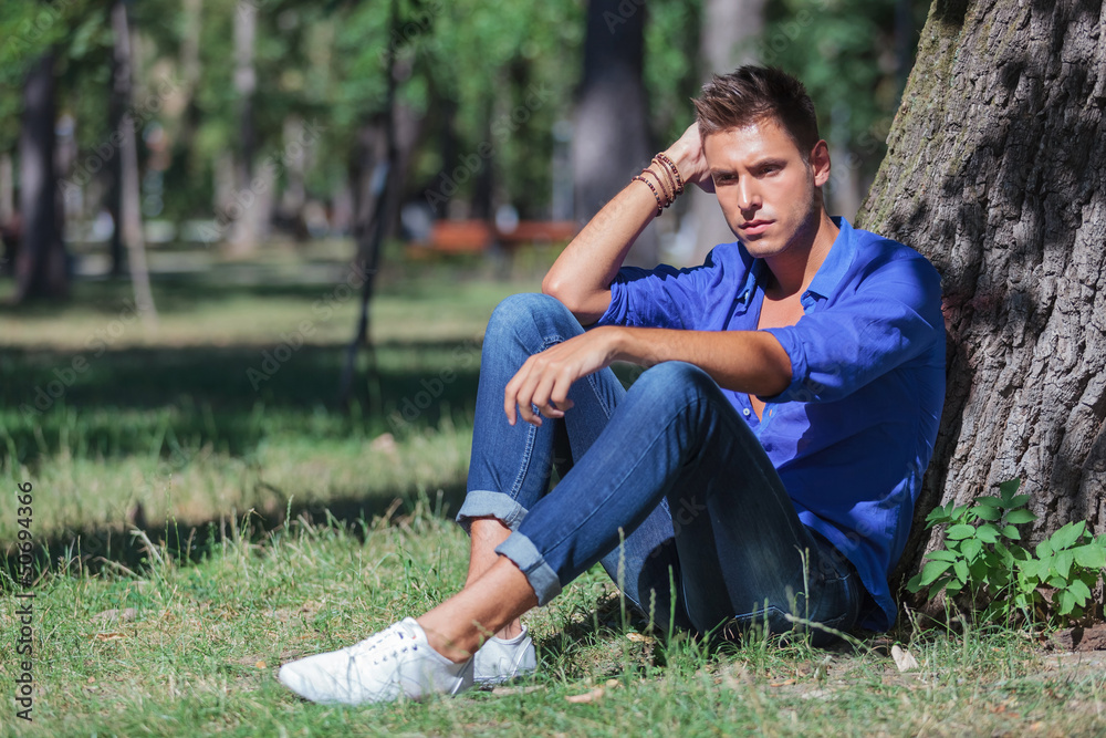 pensive man leaning on tree pensive man leaning on tree